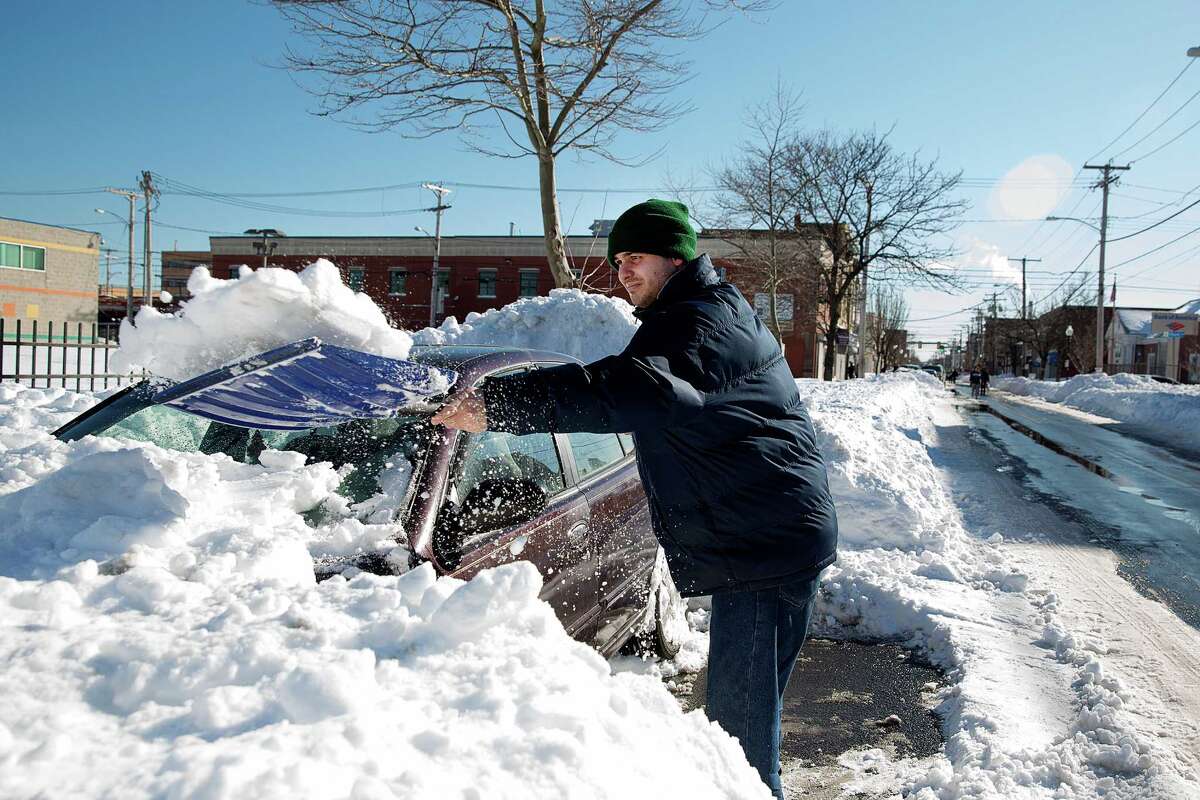 Edgar Chaves of Bridgeport works to free his late model Nissan Altima from the snow on the 1000 block of East Main St. in Bridgeport, Conn.on Sunday Feb. 10, 2013. Many residents are still digging out from the weekend blizzard.