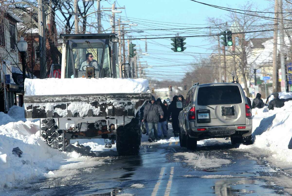 A large payloader makes it way down East Main Street in Bridgeport, Conn. to continue snow removal on Sunday Feb. 10, 2013. Town officials and residents are still working to get out from under the weekend blizzard.