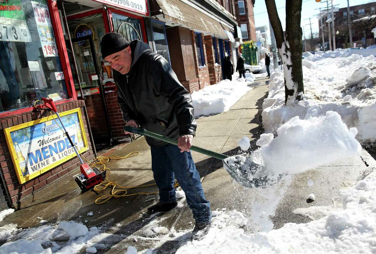 Jose Carrasquillo shovels snow in front of Mendez Wine & Liquor on East Main St. in Bridgeport, Conn. on Sunday Feb. 10, 2013.