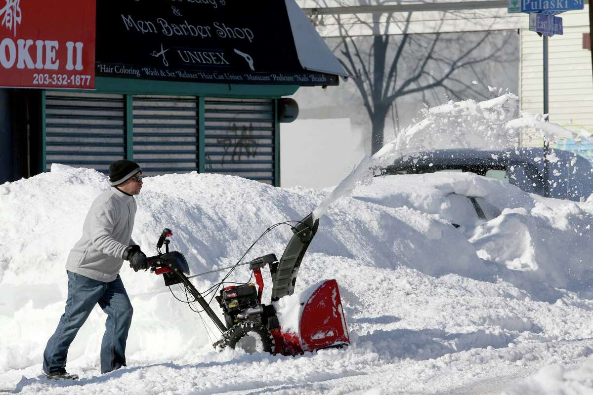Rudy Taueras uses a snow blower to clear a path for customers at Torres VarietyY Grocery on East Main Street in Bridgeport, Conn. on Sunday Feb. 10, 2013.