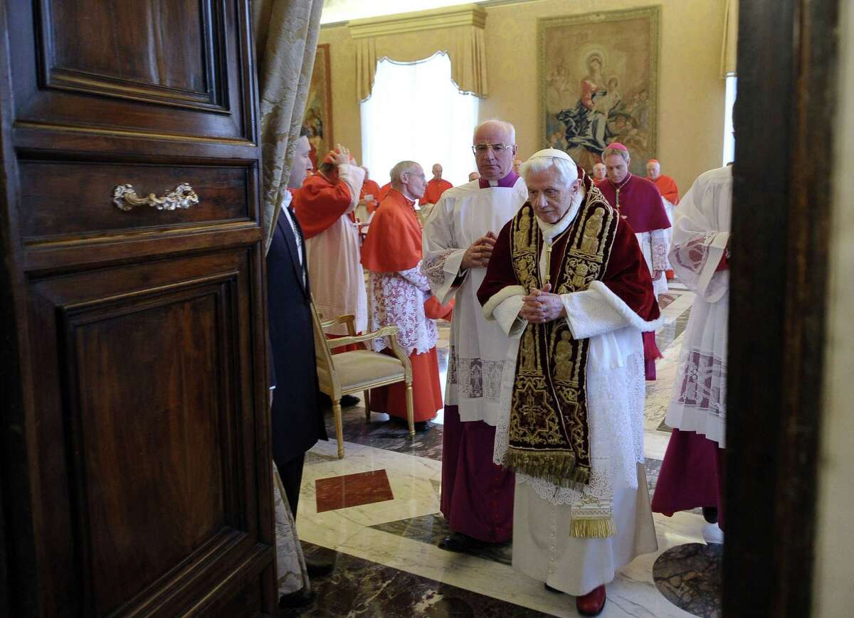 Pope Benedict XVI leaves a meeting of Vatican cardinals after announcing his resignation.