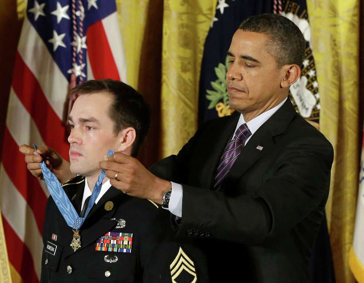 President Barack Obama bestows the Medal of Honor on retired Staff Sgt. Clinton Romesha for conspicuous gallantry, Monday, Feb. 11, 2013, in the East Room of the White House in Washington. Romesha's leadership during a daylong attack by hundreds of fighters on Combat Outpost Keating in Afghanistan led to award. (AP Photo/Pablo Martinez Monsivais)