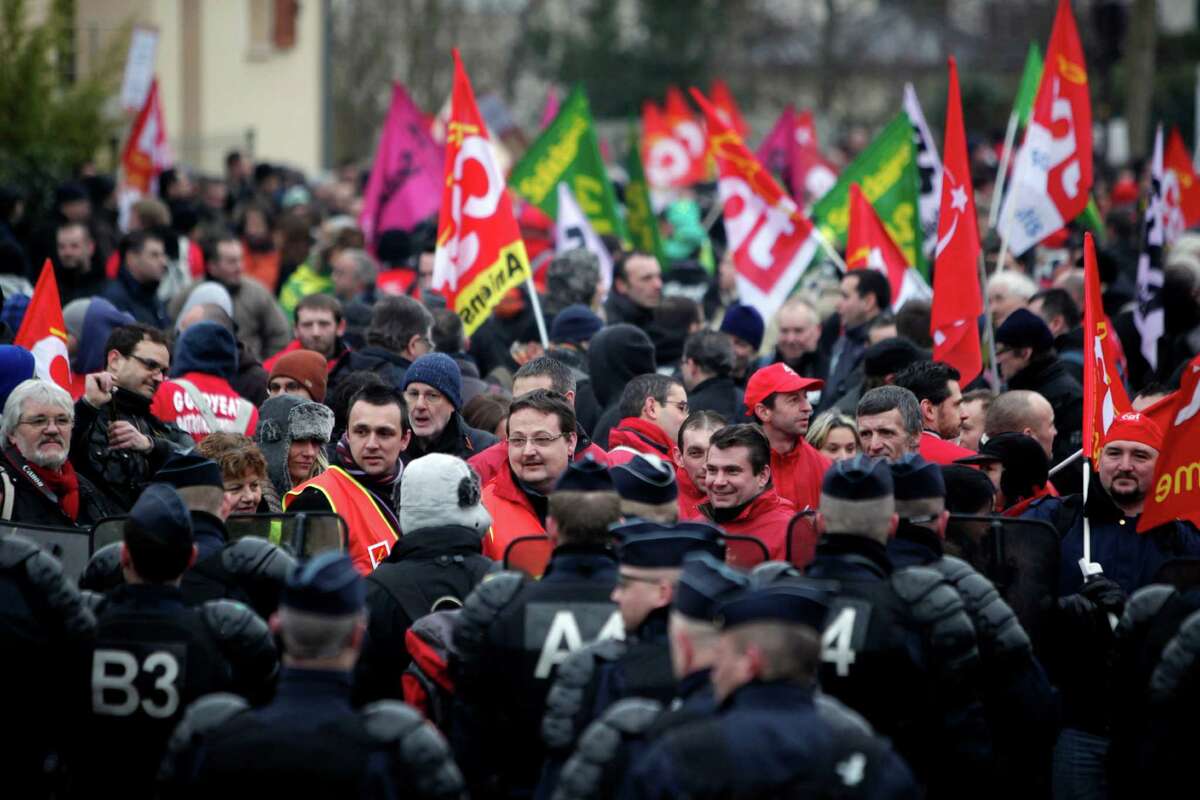 Workers of tire manufacturer Goodyear face French riot police during a demonstration in front the Goodyear headquarters, in Reuil Malmaison, outside Paris, Tuesday Feb. 12, 2013. U.S. tyremaker Goodyear confirmed in January to close a French plant near the northern city of Amiens, which would lead to the layoff of 1,173 jobs. (AP Photo/Thibault Camus)