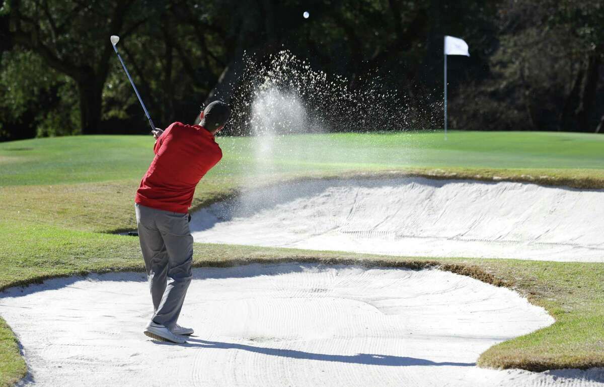 Rob Lee hits out of a bunker guarding the 18th green at Canyon Springs Golf Club. The sand traps at the course have received a new foundation that helps them drain better, thanks to a $350,000 investment from course operator Eagle Golf.