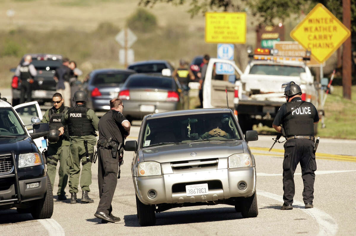 Police stand at a road block at Hwy. 38 and Bryant Street just north of Yucaipa, Calif. as a gunfight between police and fugitive ex-Los Angeles cop Christopher Dorner takes place farther up the highway in the Seven Oaks community, Tuesday, Feb. 12, 2013. (AP Photo/The Press-Enterprise, Stan Lim) NO SALES; MAGS OUT; MANDATORY CREDIT