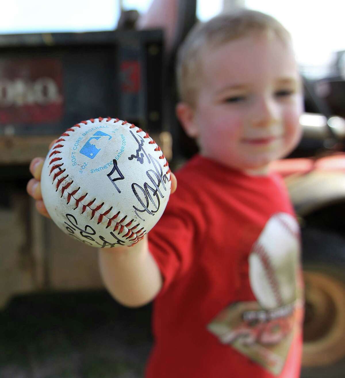 Two-year-old Wyatt Norton of Orlando shows off the fresh autographs on his new prized possession.