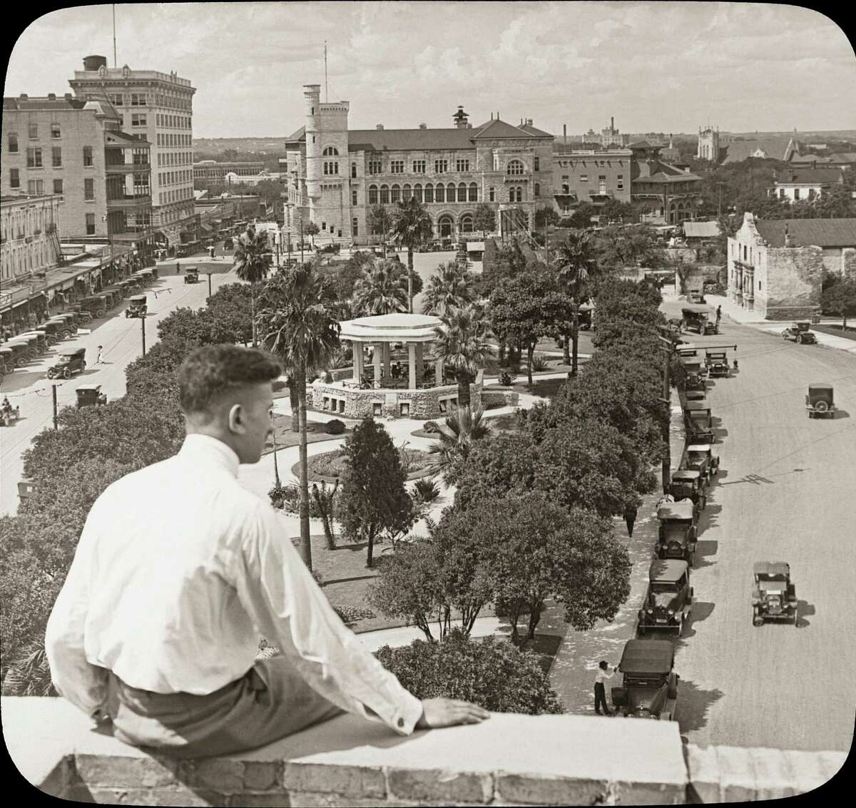In this image from the 1920s, readers of "Downtown San Antonio" can look over the shoulder of this unknown man at Alamo Plaza.