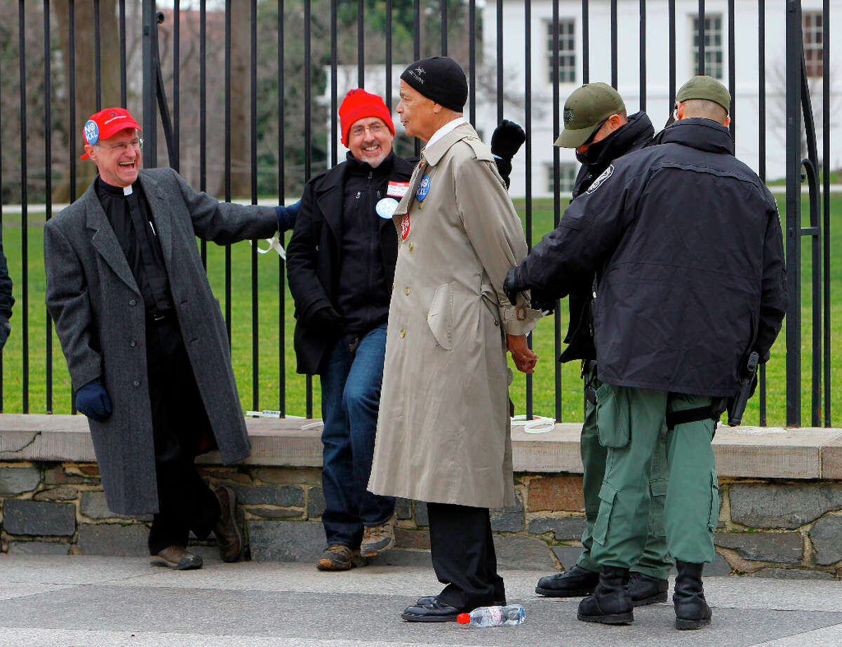 Civil rights leader Julian Bond is arrested outside the White House in Washington, Wednesday, Feb. 13, 2013, as prominent environmental leaders tied themselves to the White House gate to protest the Keystone XL oil pipeline.