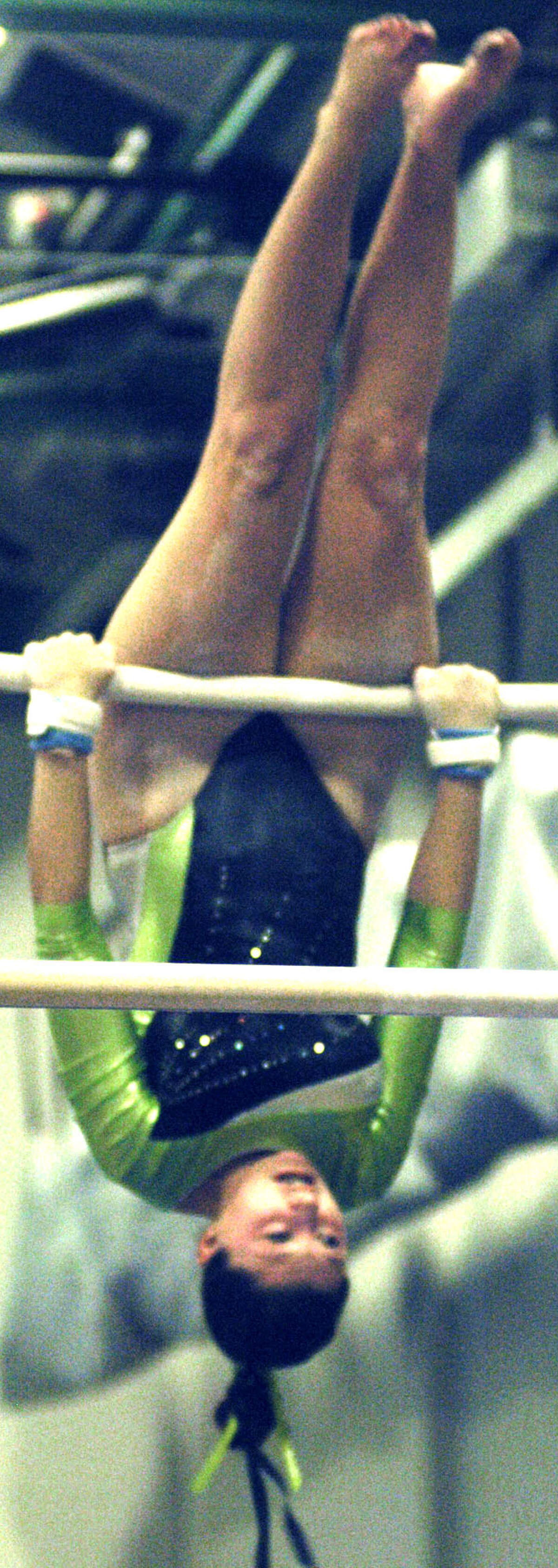 Julia Krier of the Green Wave competes on the uneven bars during a New Milford High School gymnastics meet vs. Oxford and Newtown at NMHS, Jan. 25, 2013