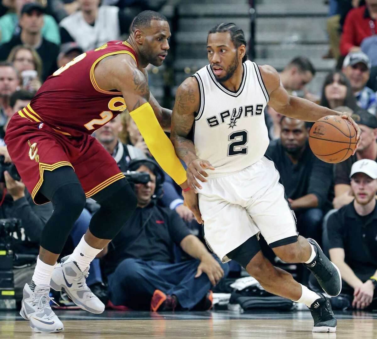 San Antonio Spurs' Kawhi Leonard looks for room around Cleveland Cavaliers' LeBron James during first half action Thursday Jan. 14, 2016 at the AT&T Center.