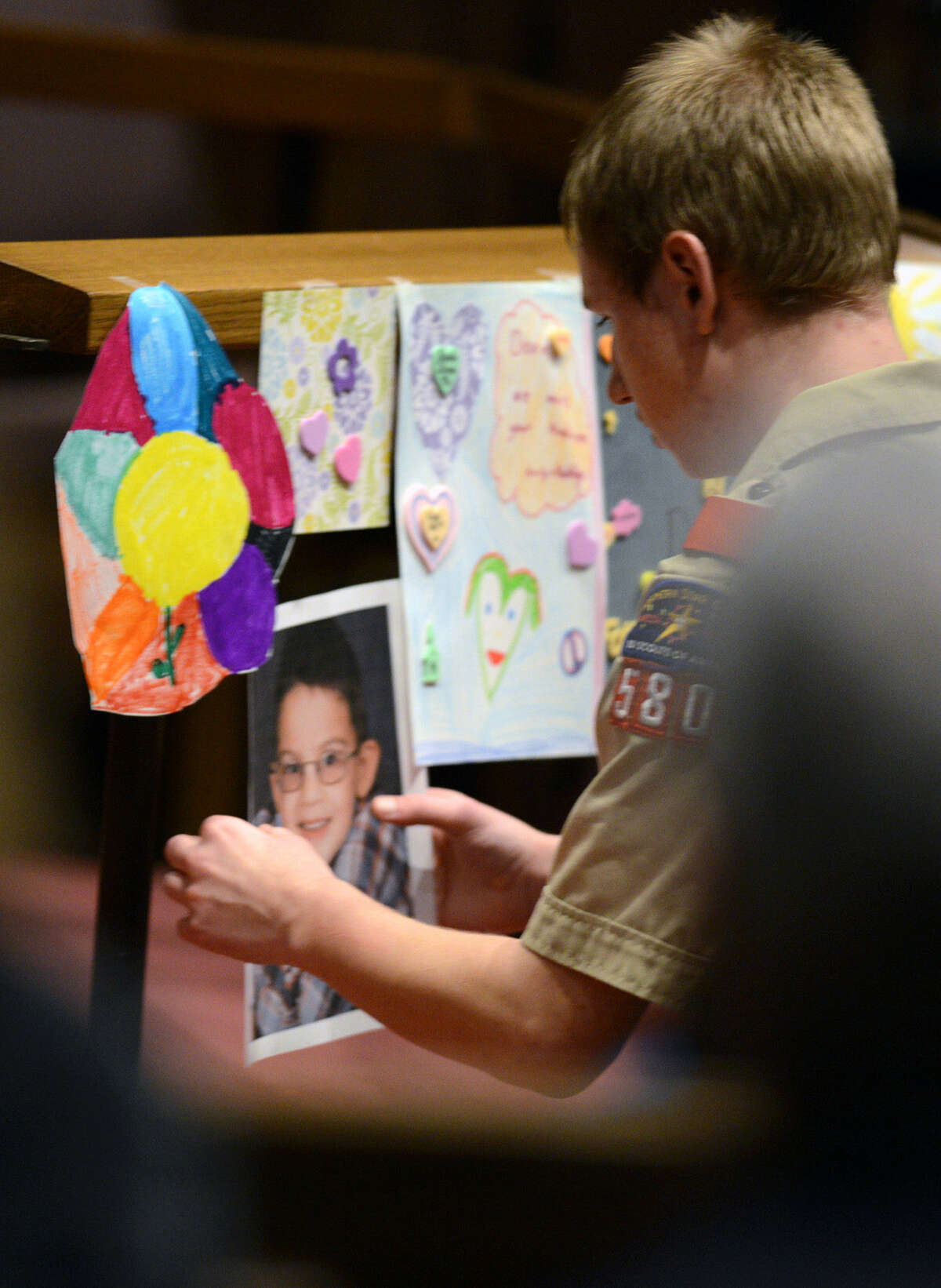 Andrew Horwath hangs a photograph of Devin Aryal, 9, at a candlelight vigil. Devin was slain in Oakdale, Minn., in an apparent random shooting.