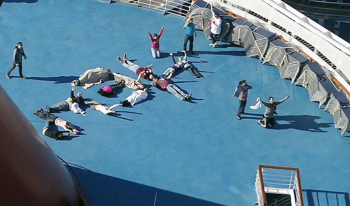 Passengers spell out the word "HELP" aboard the disabled Carnival Lines cruise ship Triumph as it is towed to harbor off Mobile Bay, Ala., Thursday, Feb. 14, 2013. The ship with more than 4,200 passengers and crew members has been idled for nearly a week in the Gulf of Mexico following an engine room fire.