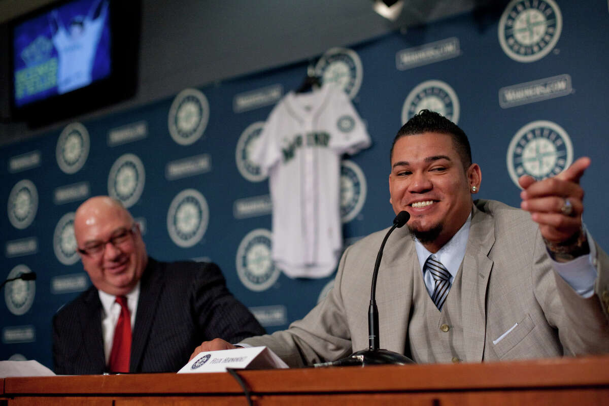Seattle Mariners pitcher Felix Hernandez points toward his family as he signs a 7 year deal with Mariners General Manger Jack Zduriencik on Wednesday, February 13, 2013 at Safeco Field in Seattle.