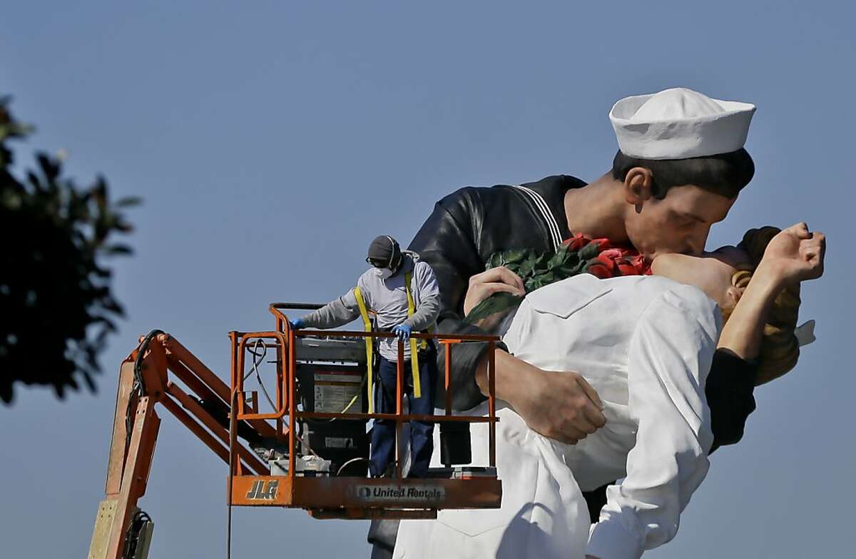 Workman put the finishing touches to the new kissing sailor statue on the embarcadero adjacent the USS Midway museum Thursday Feb. 14, 2013 in San Diego. The statue, which was modeled after the photograph by Alfred Eisenstaedt taken at the end of World War II, replaces a similar version that was moved out of San Diego last year. (AP Photo/Lenny Ignelzi)