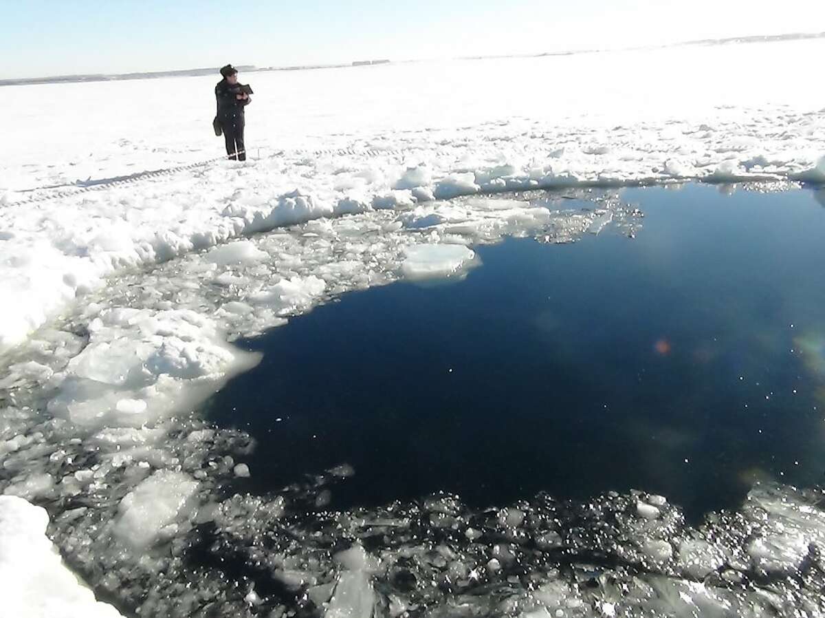 A circular hole in the ice of Chebarkul Lake where a meteor reportedly struck the lake near Chelyabinsk, about 1500 kilometers (930 miles) east of Moscow, Russia, Friday, Feb. 15, 2013. A meteor streaked across the sky and exploded over Russia's Ural Mountains with the power of an atomic bomb Friday, its sonic blasts shattering countless windows and injuring nearly 1,000 people. (AP Photo)