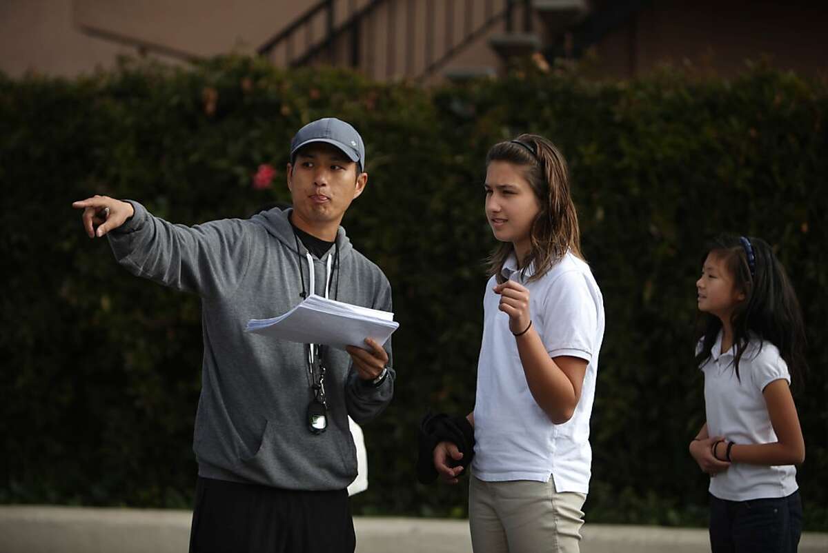 PE instructor Daniel Eng (l to r) gives instruction to Emma Fisher, 11, during sixth grade PE class at the American Indian Public Charter School on Wednesday, February 13, 2013 in Oakland, Calif.