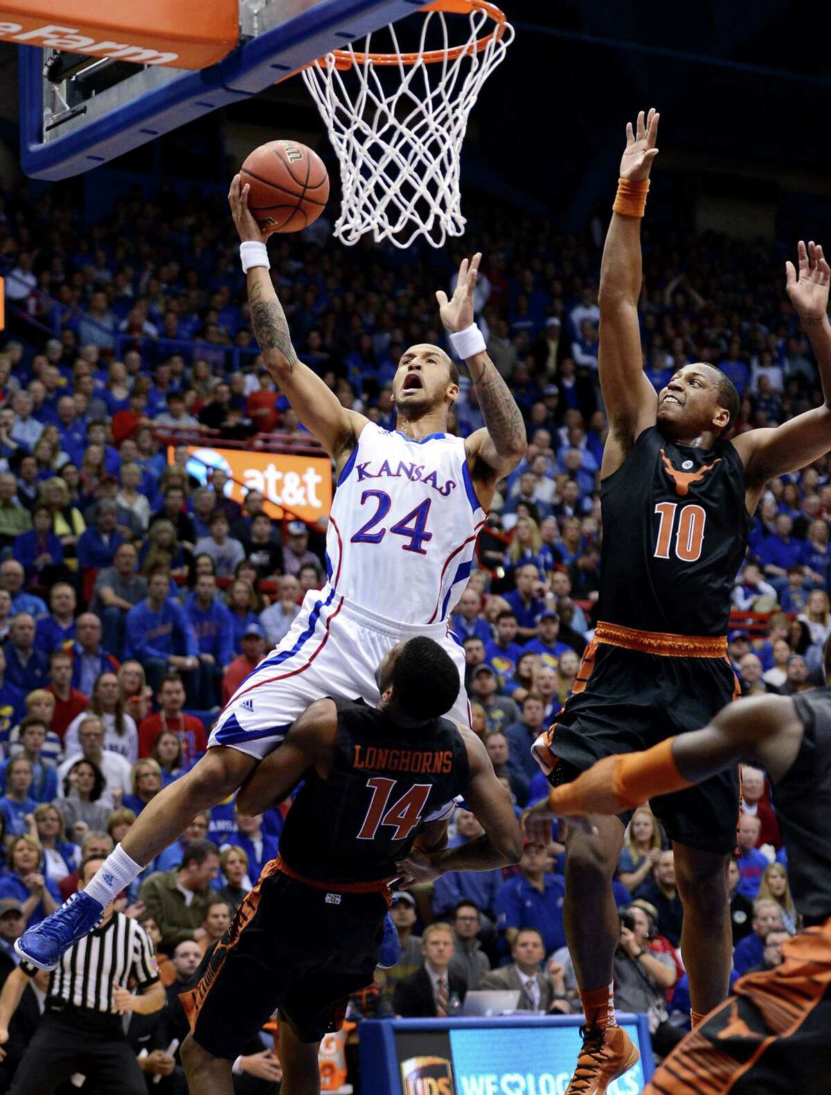 Kansas' Travis Releford soars in for a layup past Texas' Jonathan Holmes (right) and over Julien Lewis during the first half at Allen Fieldhouse on Saturday. Releford finished with a game-high 15 points.