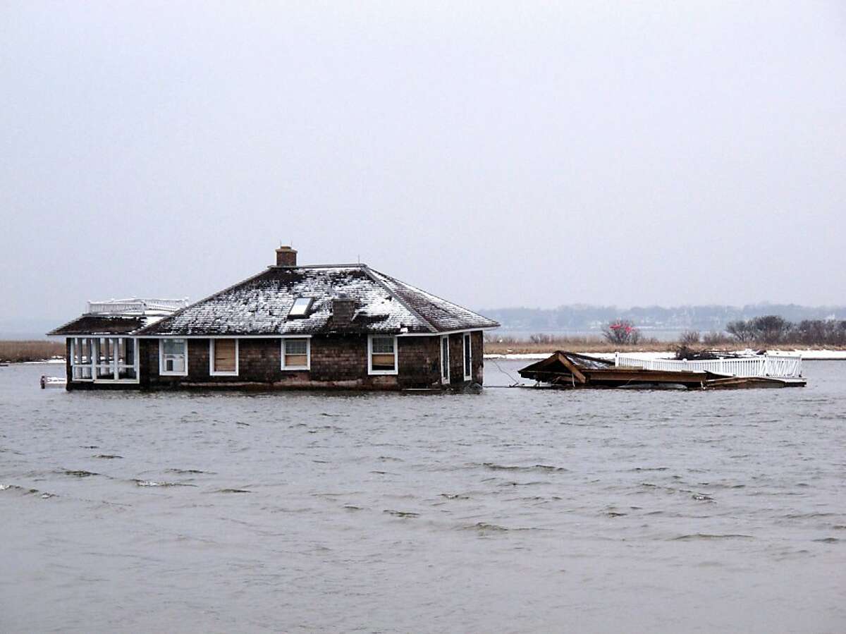 This Feb. 5, 2013, photo,shows a home in the middle of Barnegat Bay, that was washed into the Bay from Mantoloking N.J. during Superstorm Sandy. States hit hard by Sandy are gearing up to remove tons of debris from waterways, including houses, vehicles, sunken boats, furniture, pieces of piers, decks and bulkheads _ all of which must be removed before the summer swimming and boating season. (AP Photo/Wayne Parry)