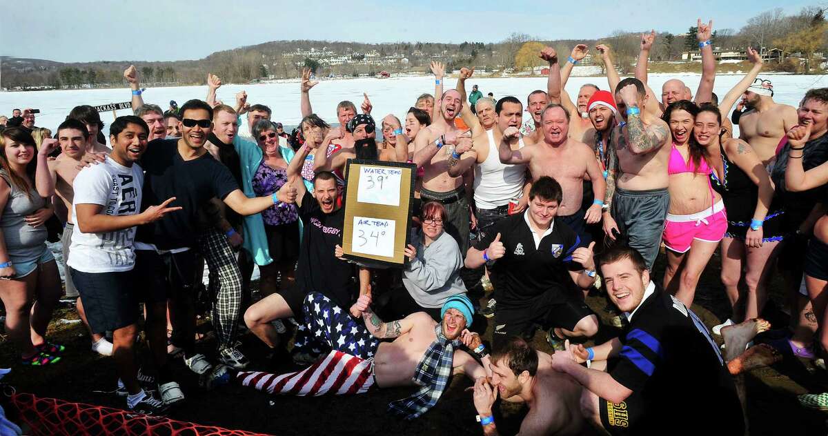 Dippers pose for the crowd of spectators before plunging into the icy waters of Lake Kenosia, outside the Moose Lodge, at the Jack Knapp Sr. Danbury Dip for Charity Saturday, Feb. 16, 2013, in Conn.