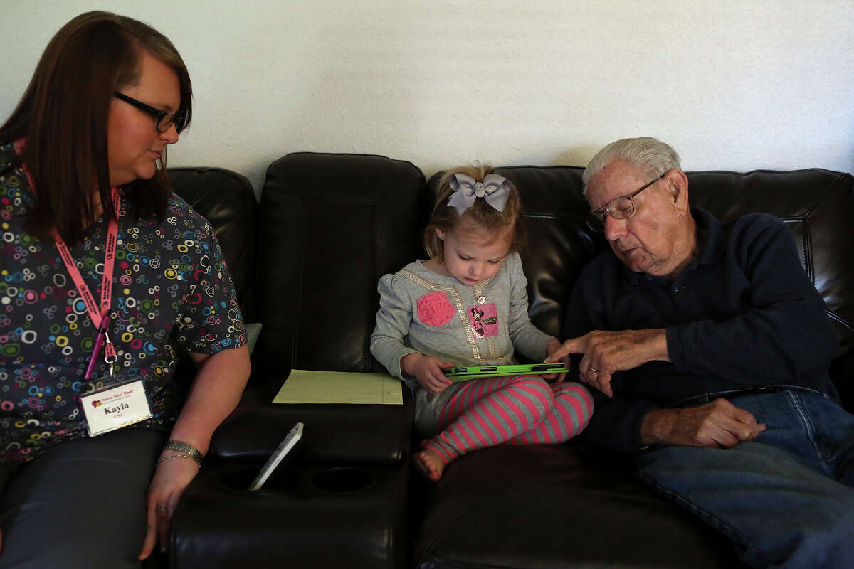 George Roeber, 92, plays with his granddaughter Sadie Schuetze, 3, as Kayla Hester, CNA, of Nurse Next Door home health care, looks on at his home in San Antonio on Friday, Feb. 1, 2013.