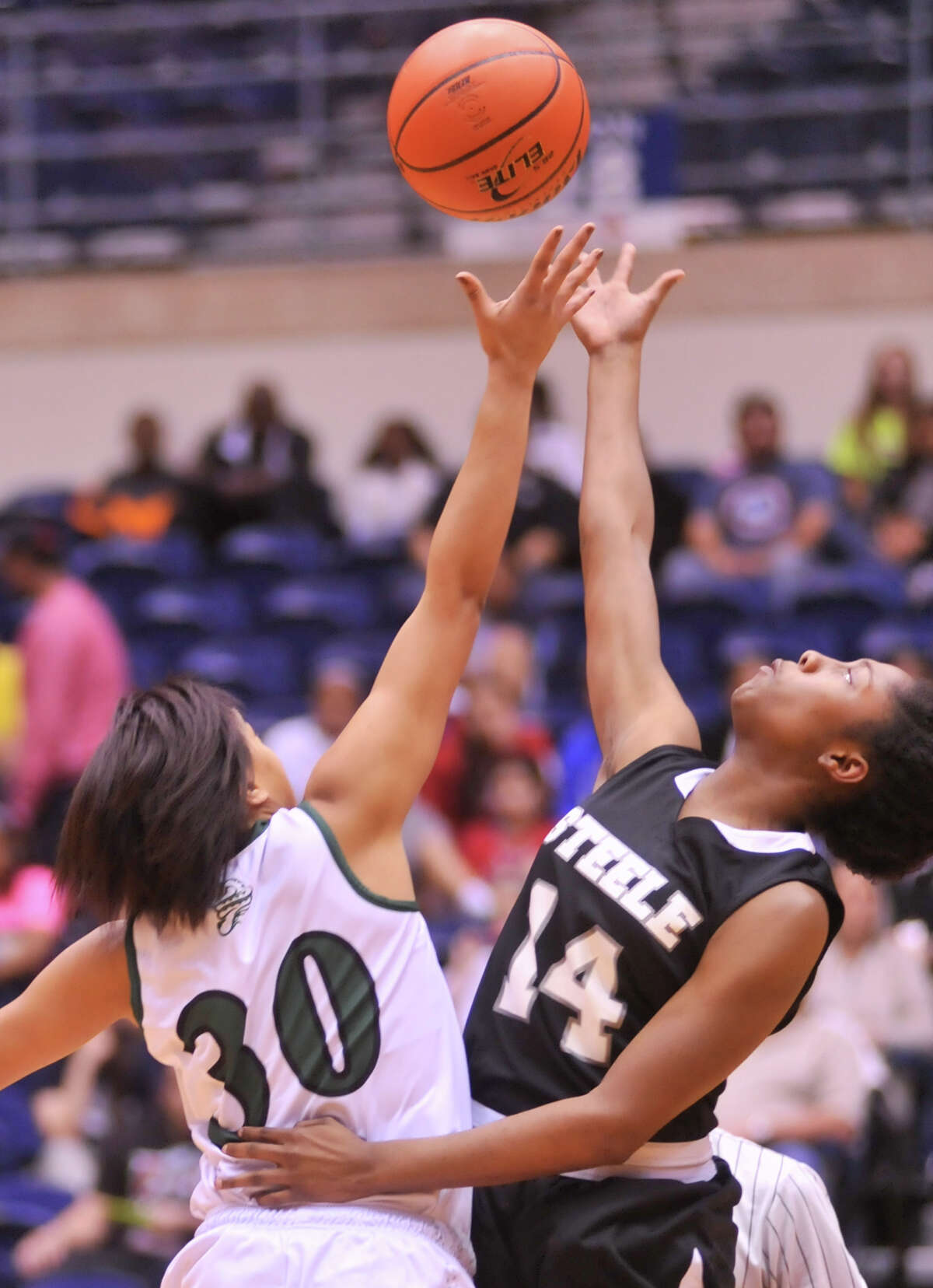 Reagan's Briana Gladney (30) and Steele's McKenzie Calvery (14) battle for control of the open tip during their 5A playoff game Tuesday, Feb. 19, 2013.