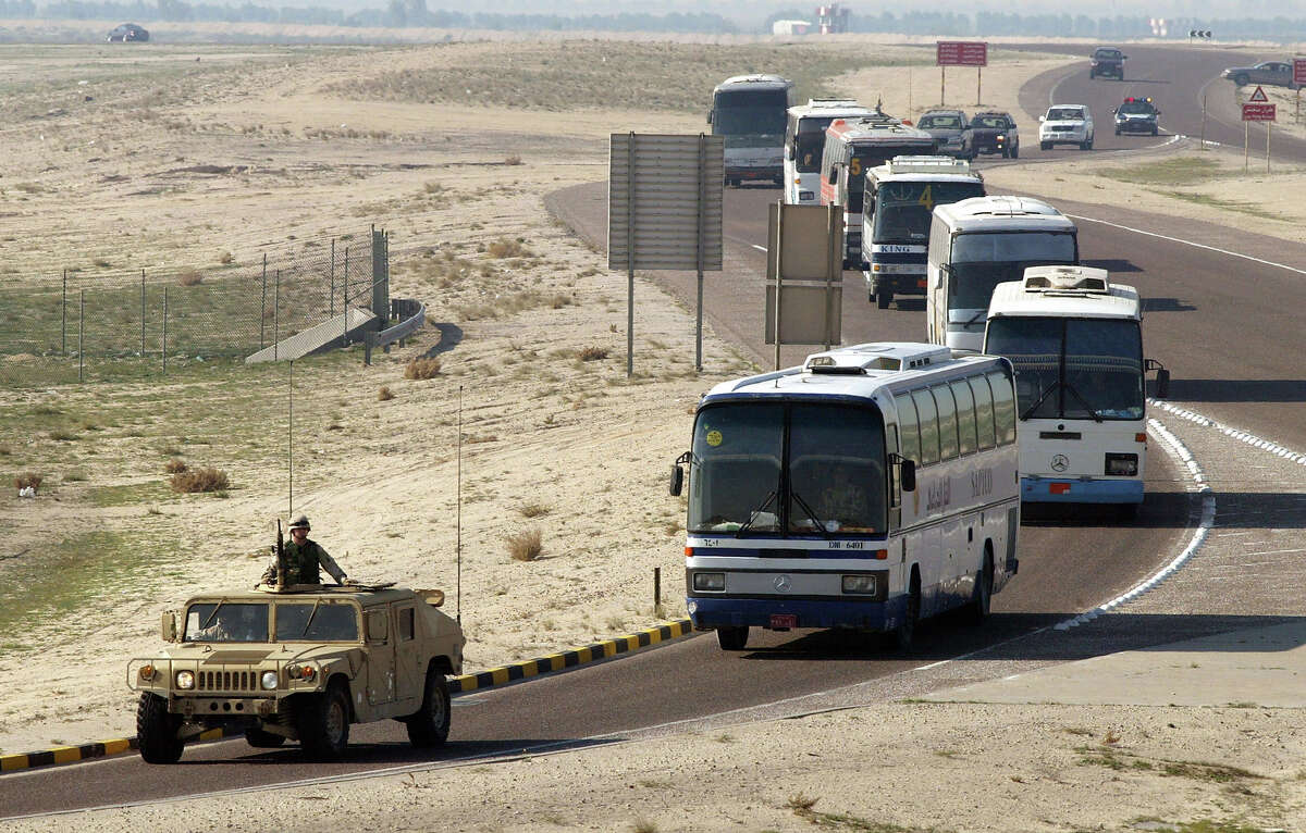 A U.S. Army Humvee escorts civilian buses loaded with U.S. soldiers from the International Airport January 10, 2003 in Kuwait City. The United States continues a low key influx of troops in the biggest military buildup in the region since the Gulf War.