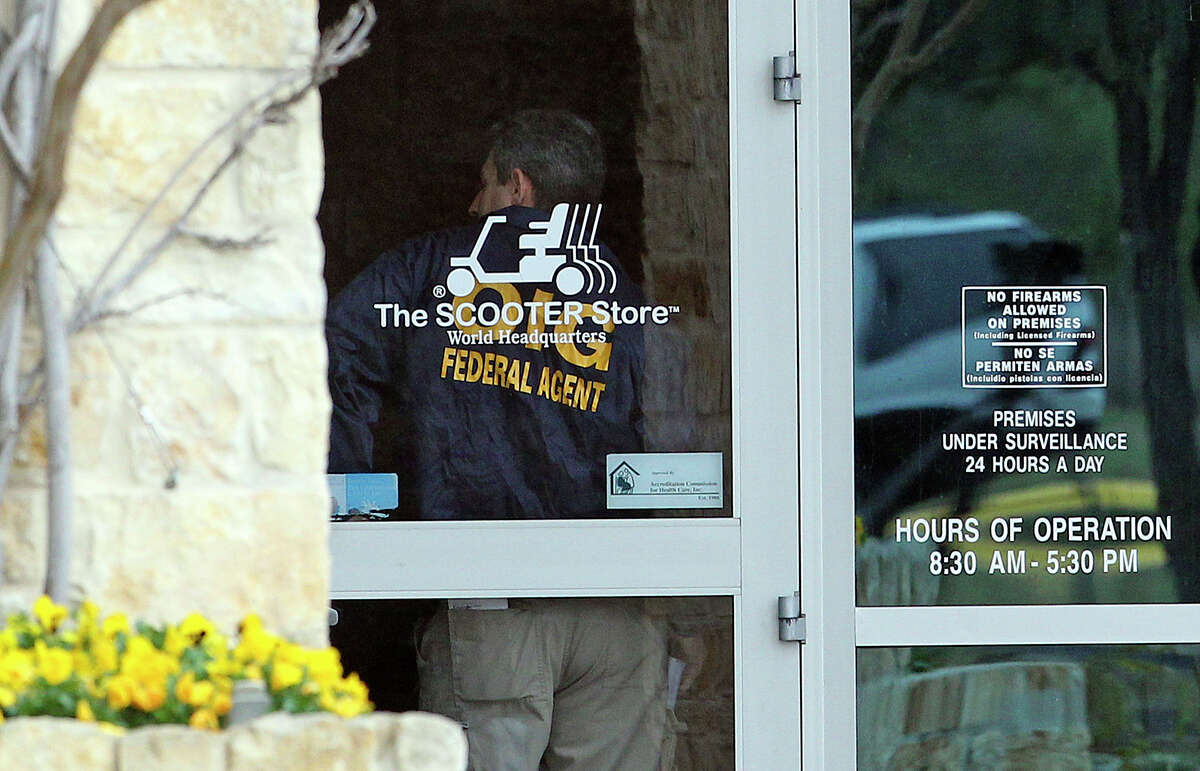 An agent stands at the front door of the building number 1 as FBI and OIG search the Scooter Store in New Braunfels on February 20, 2013.
