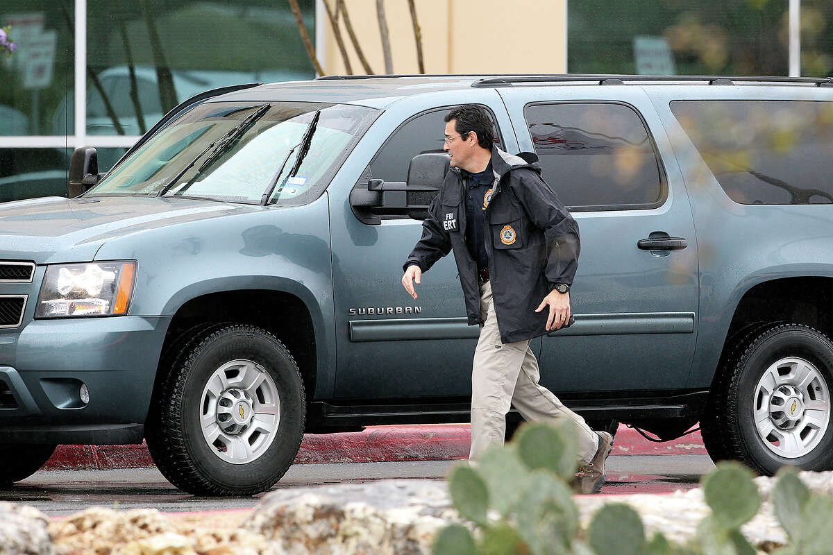 An FBI agent hrries into the front of the building after exiting his vehicle as FBI and OIG raid the Scooter Store in New Braunfels on February 20, 2013.