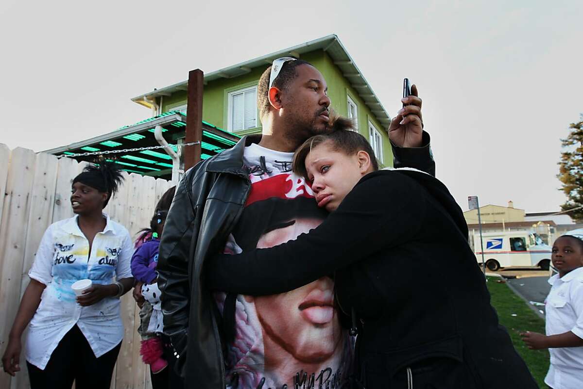 Brijjanna Price, 17, hugs her father Ramon Price Sr. during the vigil marking the one-year anniversary of her brother Lamont Price's murder, Saturday February 16, 2013, in Oakland. Price, 17, was one of the 131 homicides in 2012.