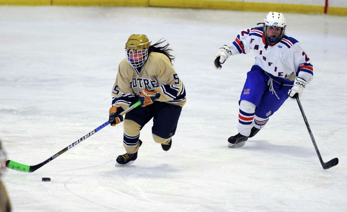 Notre Dame-Fairfield's Bailey Brown controls the puck as Fairfield Warde/Ludlowe's Tabby Cascella defends during their ice hockey game at Wonderland of Ice in Bridgeport, Conn. Wednesday, Feb. 20, 2013.