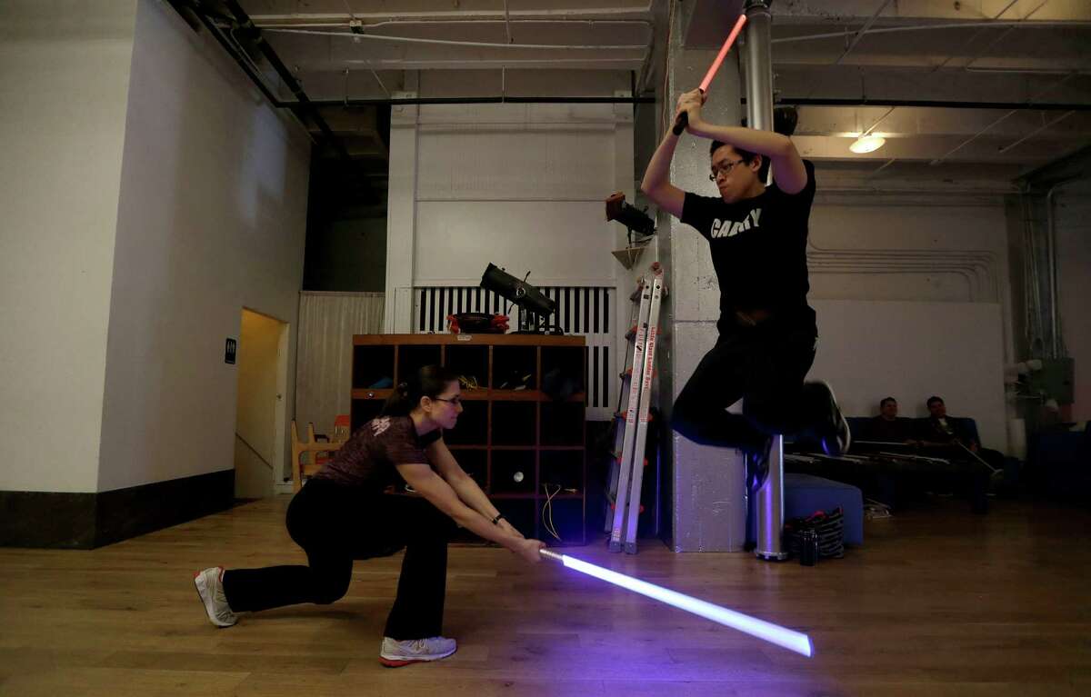 Student Aaron Cheng jumps over a light saber swung by fellow student Starshine Medeiros during a Golden Gate Knights class in San Francisco, Sunday, Feb. 10, 2013. A group of San Francisco Star Wars fans who want to travel to a galaxy not that far away have created a combat choreography class for Jedis-in-training with their weapon of choice: the light saber.