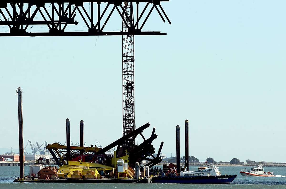 A construction crane removing the temporary supports under the eastern section of the new Bay Bridge toppled over this afternoon onto the barge that was carrying it in Oakland, Calif., on Thursday Feb. 21 2013.