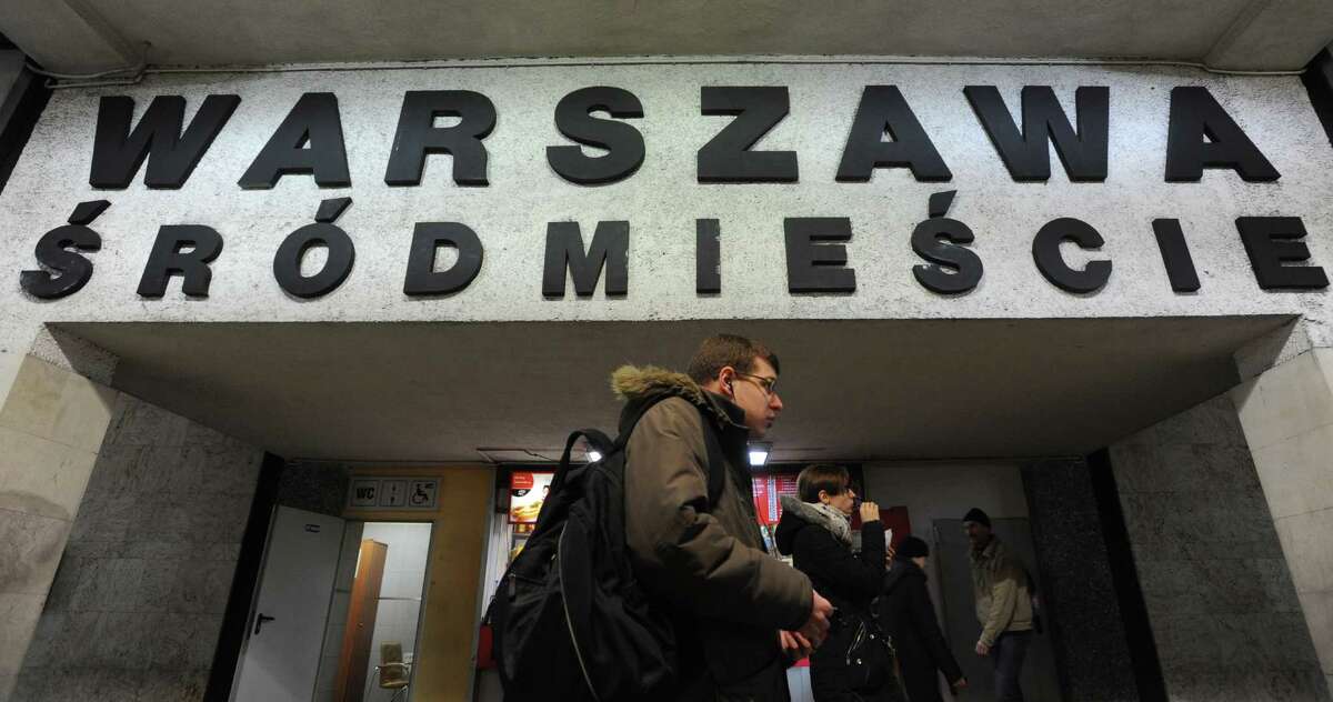People walk under a board with the name of a train station with several Polish diacritical marks, in Warsaw, Poland, Thursday, Feb. 21, 2013. Polish language experts have launched a campaign, as part of the UNESCO International Mother Language Day, to preserve the challenging system of its diacritical marks, saying the tails, dots and strokes are becoming obsolete under the pressure of IT and speed. The name of the station reads Warsaw Downtown. (AP Photo/Alik Keplicz)