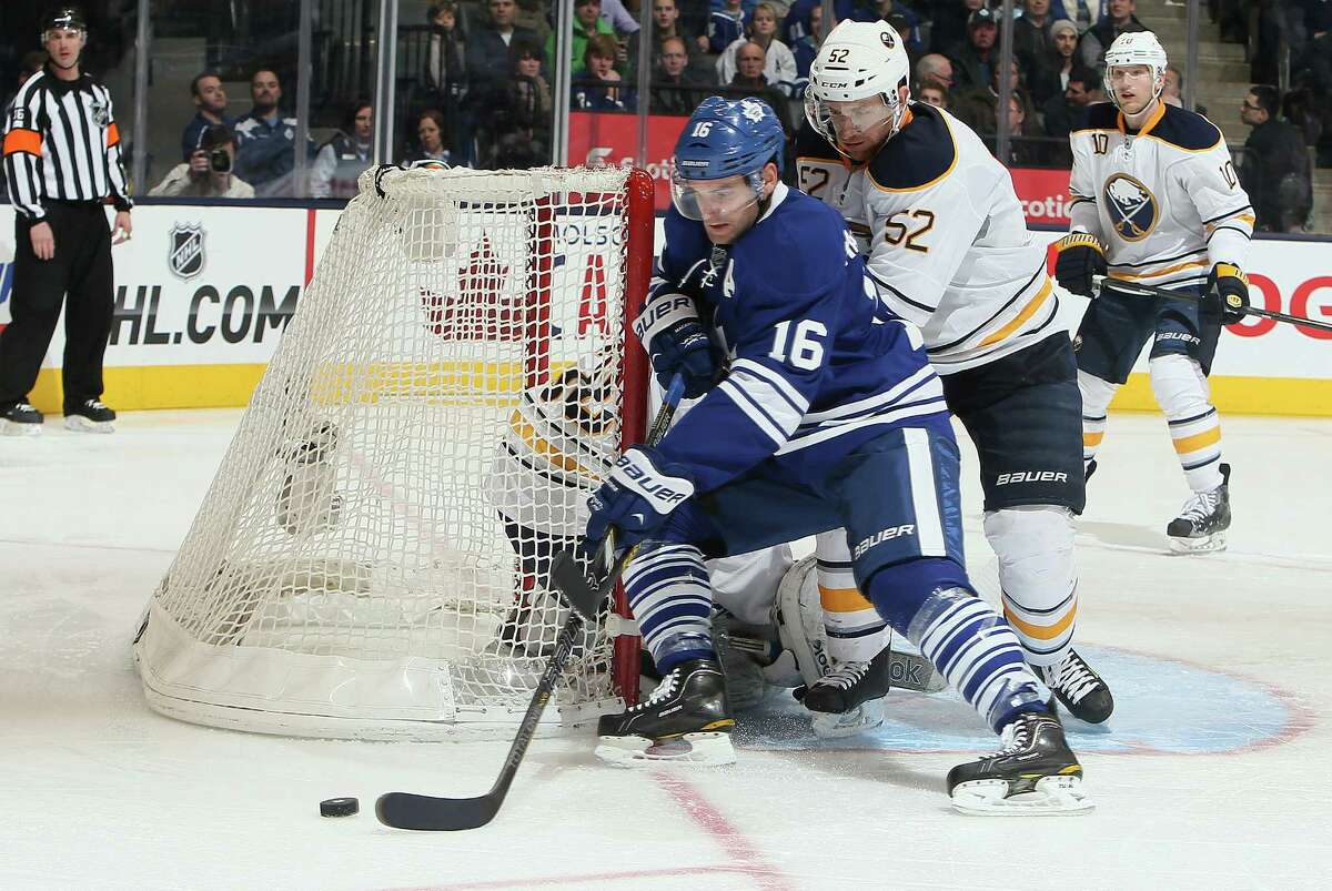 TORONTO, CANADA - FEBRUARY 21: Clarke MacArthur #16 of the Toronto Maple Leafs drives the net on Alexander Sulzer #52 of the Buffalo Sabres during NHL action at the Air Canada Centre February 21, 2013 in Toronto, Ontario, Canada. (Photo by Abelimages/Getty Images)