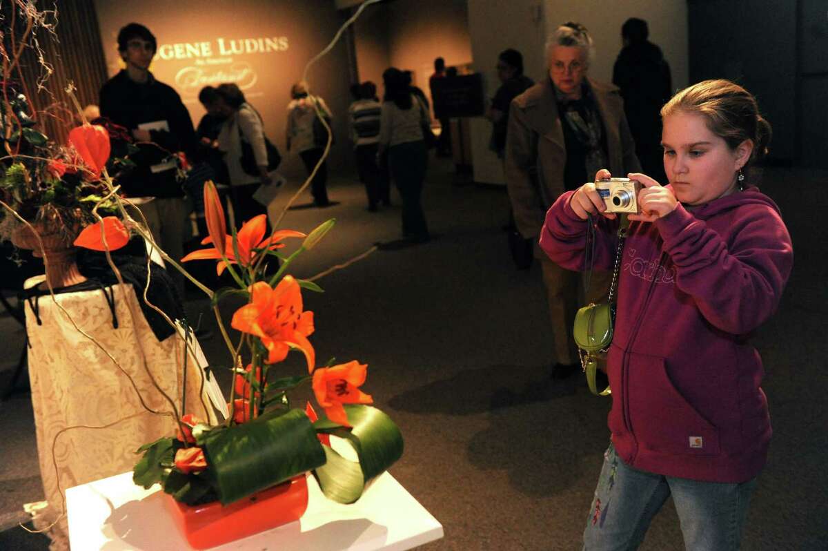 Ten-year-old Sophia VanDerwarker photographs a floral design by Pamela Love of the Van Rensselaer Garden Club during the 22nd Annual New York in Bloom at the New York State Museum on Saturday Feb. 23, 2013 in Albany, N.Y. (Michael P. Farrell/Times Union)