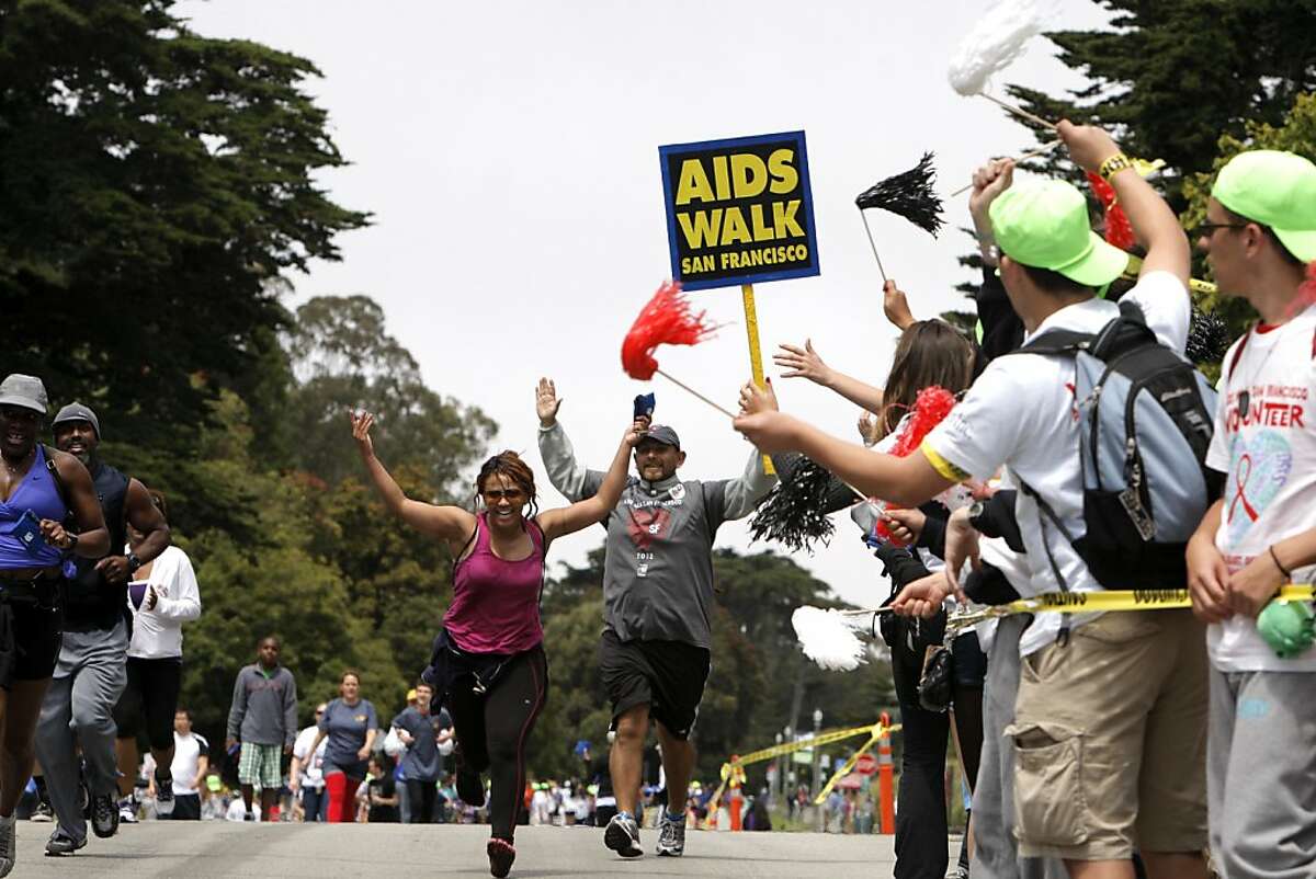 Sheila Thomas and Francisco Martinez cross the finish line during the San Francisco AIDS Walk in Golden Gate Park. The San Francisco AIDS Walk took place in Golden Gate Park on Sunday, July 15, 2012, in San Francisco, Calif.
