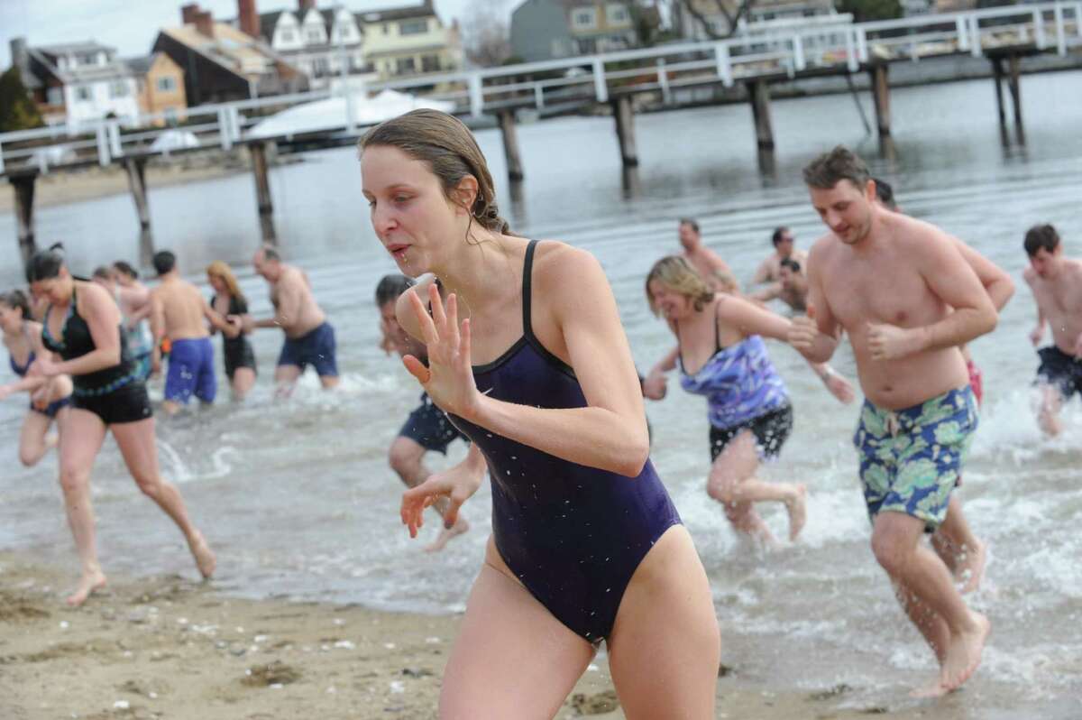 A guest runs out of the water at Family Centers of Greenwich's second annual Polar Bear Plunge in the Long Island Sound at Geneve Holdings, in Stamford, Conn., Sunday, Feb. 24, 2013, to benefit The Den for Grieving Kids, a Family Centers program.