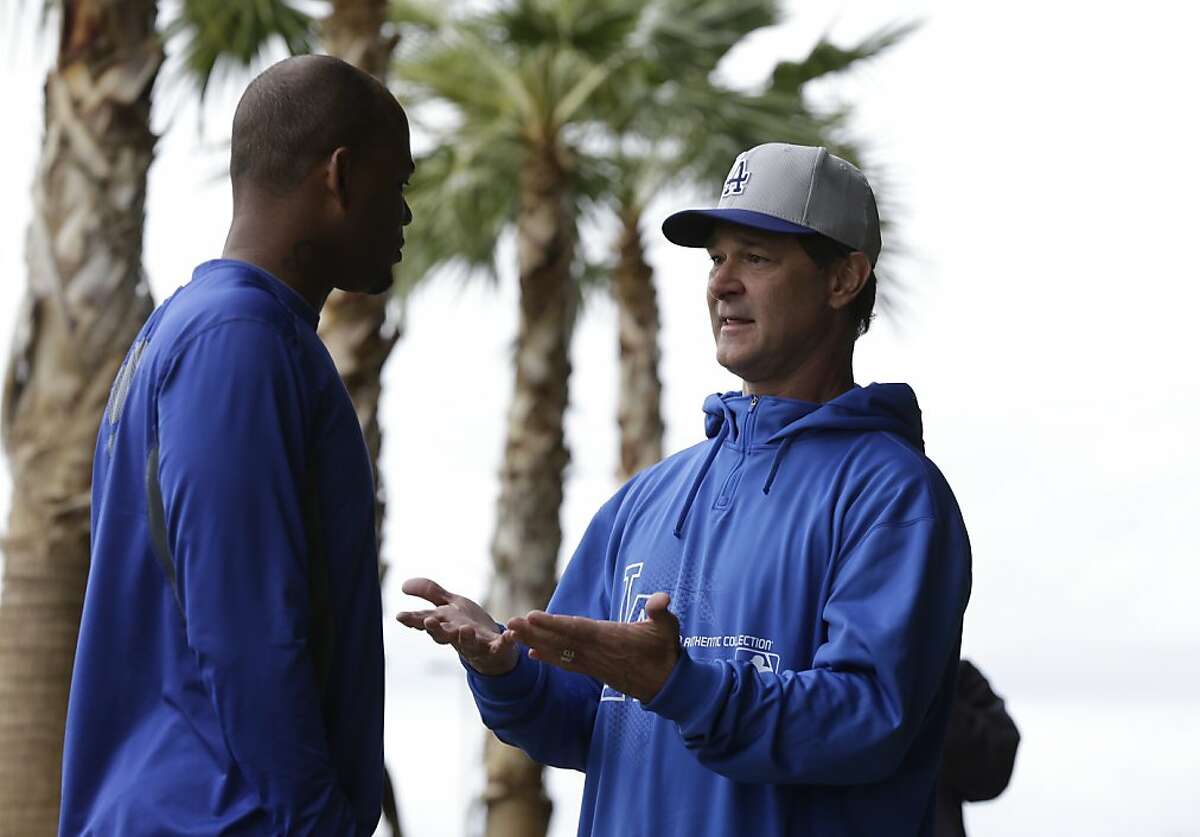Los Angeles Dodgers manager Don Mattingly, right, talks with outfielder Carl Crawford during spring training baseball in Phoenix, Wednesday, Feb. 20, 2013. (AP Photo/Paul Sancya)