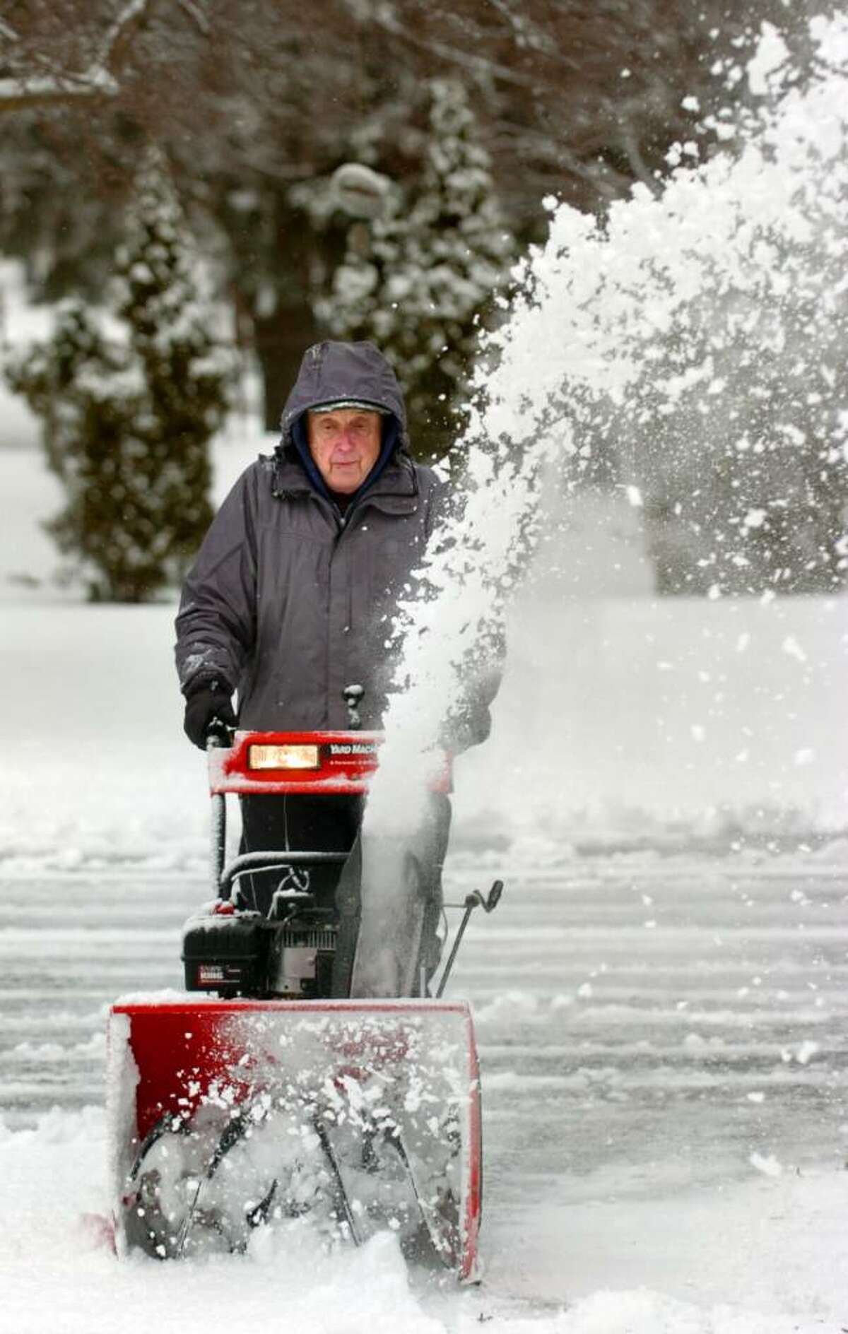 George Raslavsky snow blows his Ansonia driveway Thursday morning.