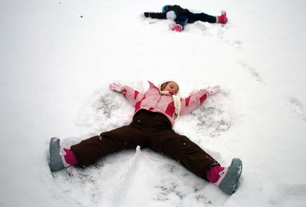 Six-year-old Maeve Malone, of Orange, makes a snow angel Thursday at the Ansonia Nature Center during their Winter Holiday Nature Days program.