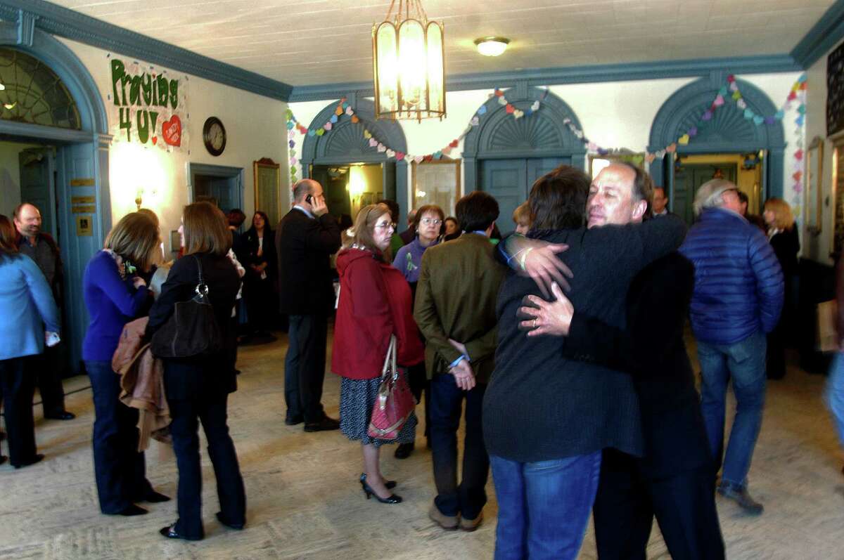 Mark Barden, right, hugs another Sandy Hook parent as audience members wait the start of a taping of Katie Couric's show in Edmond Town Hall, about the Sandy Hook shootings, in Newtown, Conn. Monday, Feb. 25, 2013. Barden lost his son in the shooting.