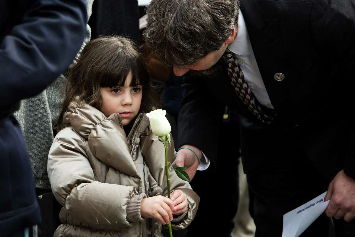 NEW YORK, NY - FEBRUARY 26: Stephen Knapp, a son of a victim from the 1993 World Trade Center bombing, comforts his daughter Alyssa Knapp, age 4, during the 20th Anniversary Ceremony at Ground Zero on February 26, 2013 in New York City. The attack, which utilized a car bomb and hit the north tower, killed six people.