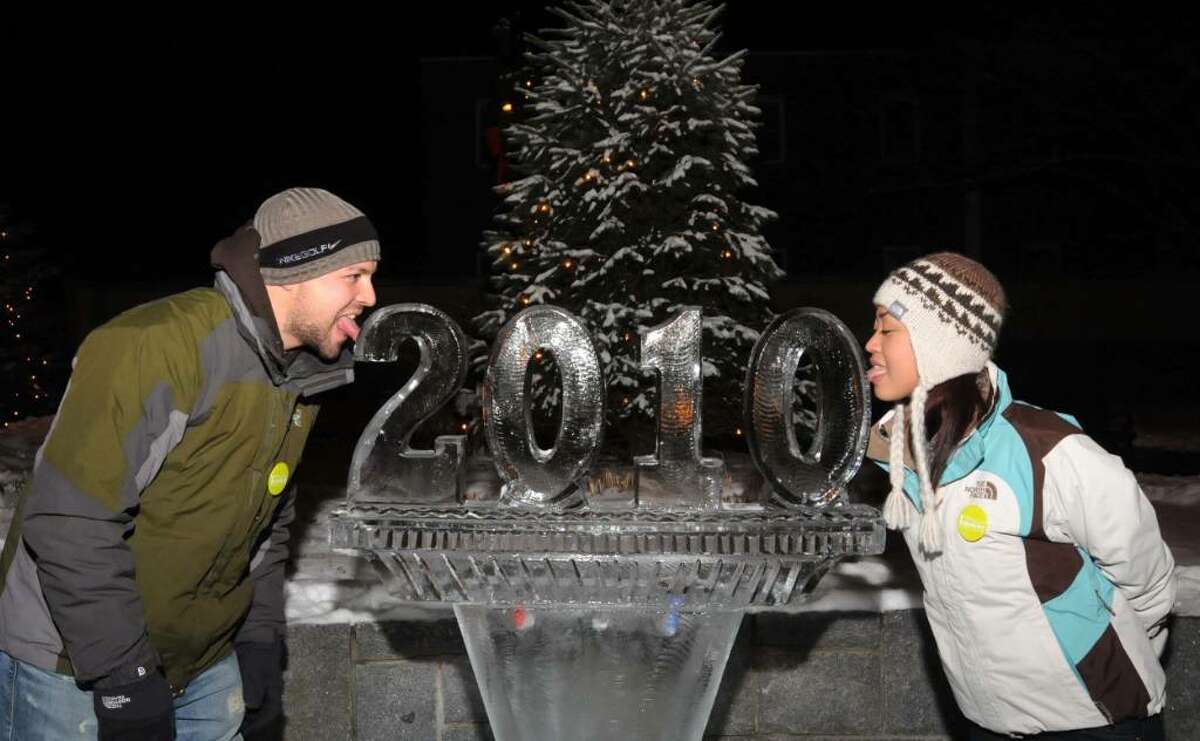 Chris Scott, 30 on the left and Jackie Scott, 28, both from Jacksonville, N.C. visiting tried their luck at the Danbury First Night celebration on Thursday Dec. 31, 2009 by touching their tongues to the freshly carved 2010 ice sculpture in the court yard of the Danbury Public Library.