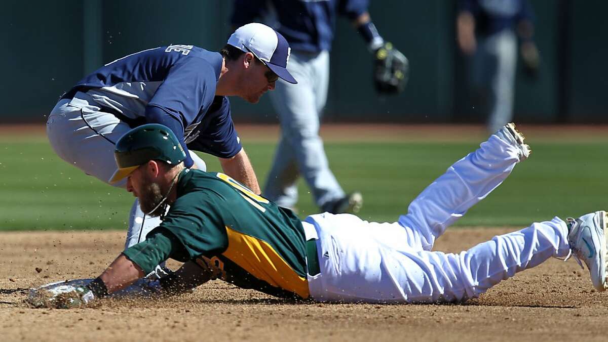 Oakland Athletics Daric Barton slides safely into second base in front of San Diego Logan Forsythe Wednesday, Feb. 27, 2013, during their exhibition spring training baseball game in Phoenix, Ariz.
