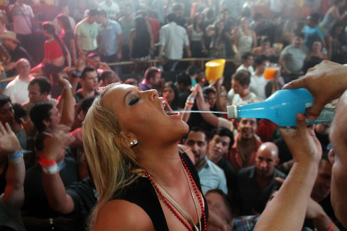 A spring break reveler gets a drink at a bar in the resort city of Cancun, Mexico, early Tuesday Feb. 26, 2013. Cancun is one of the No. 1 foreign destination for U.S. college students wanting to enjoy Spring Break. (AP Photo/Israel Leal)