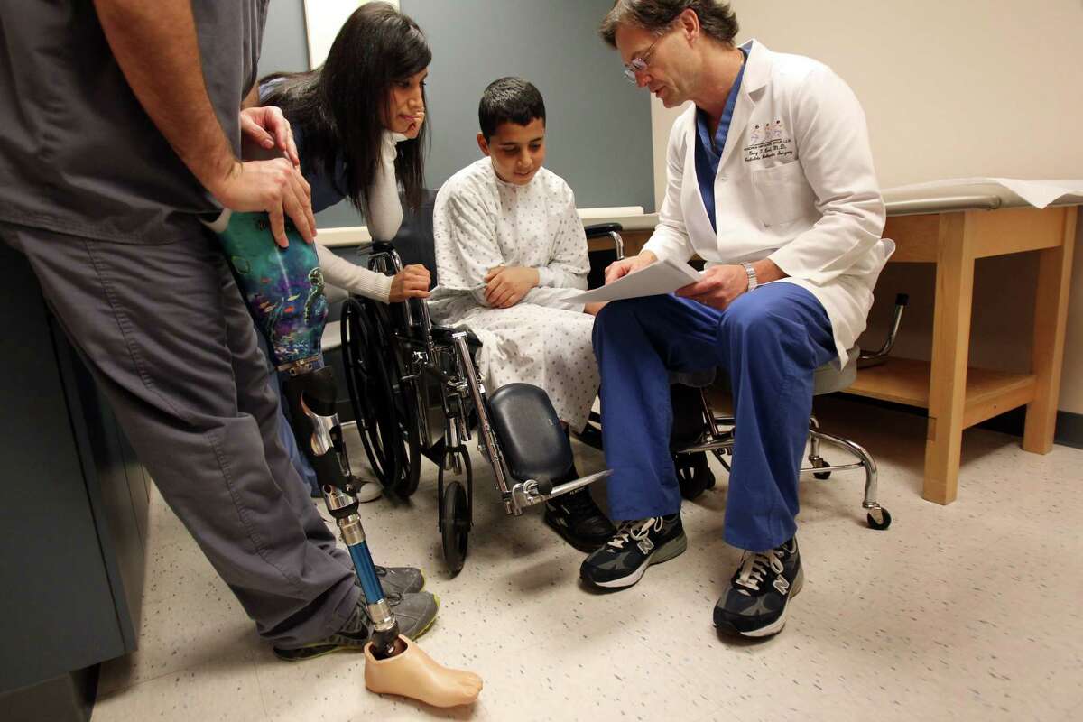 Mohammed Jammous, 14, with Dr. Gary Brock and translator Duha Ayish, came to Houston for a prosthetic.