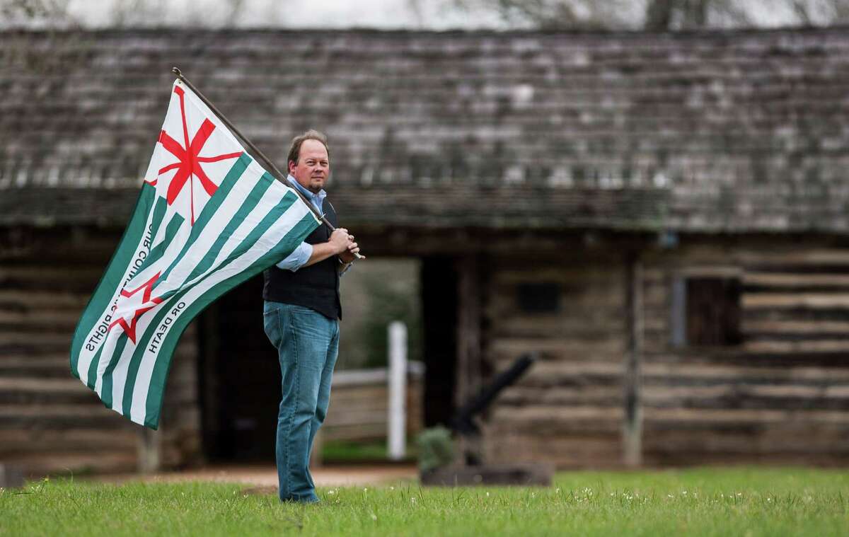 Brian McAuley, manager of the Austin County site, with the San Felipe Flag designed for the Texas Militia in 1836. "This is not a forgotten place," he says.