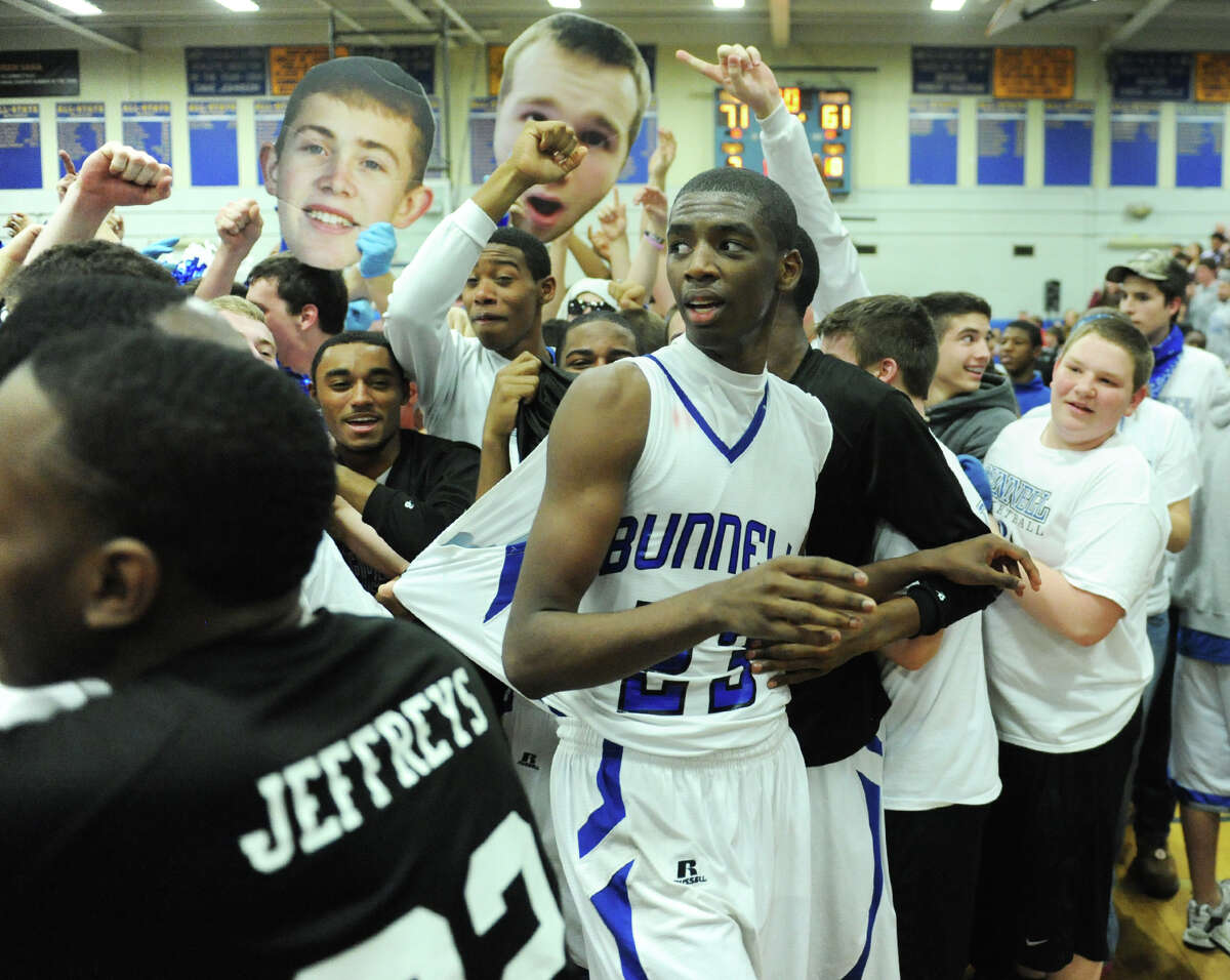 Bunnell players are mobbed as their home crowd rushes the court after their 71-61 win over Bethel in the SWC Boys Basketball Championship game at Bunnell High School in Stratford, Conn. Thursday, Feb. 28, 2013.