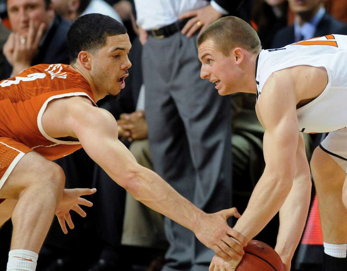 Texas' Javan Felix, left, reaches for the ball and gets the hand of Oklahoma State's Phil Forte in the first half.