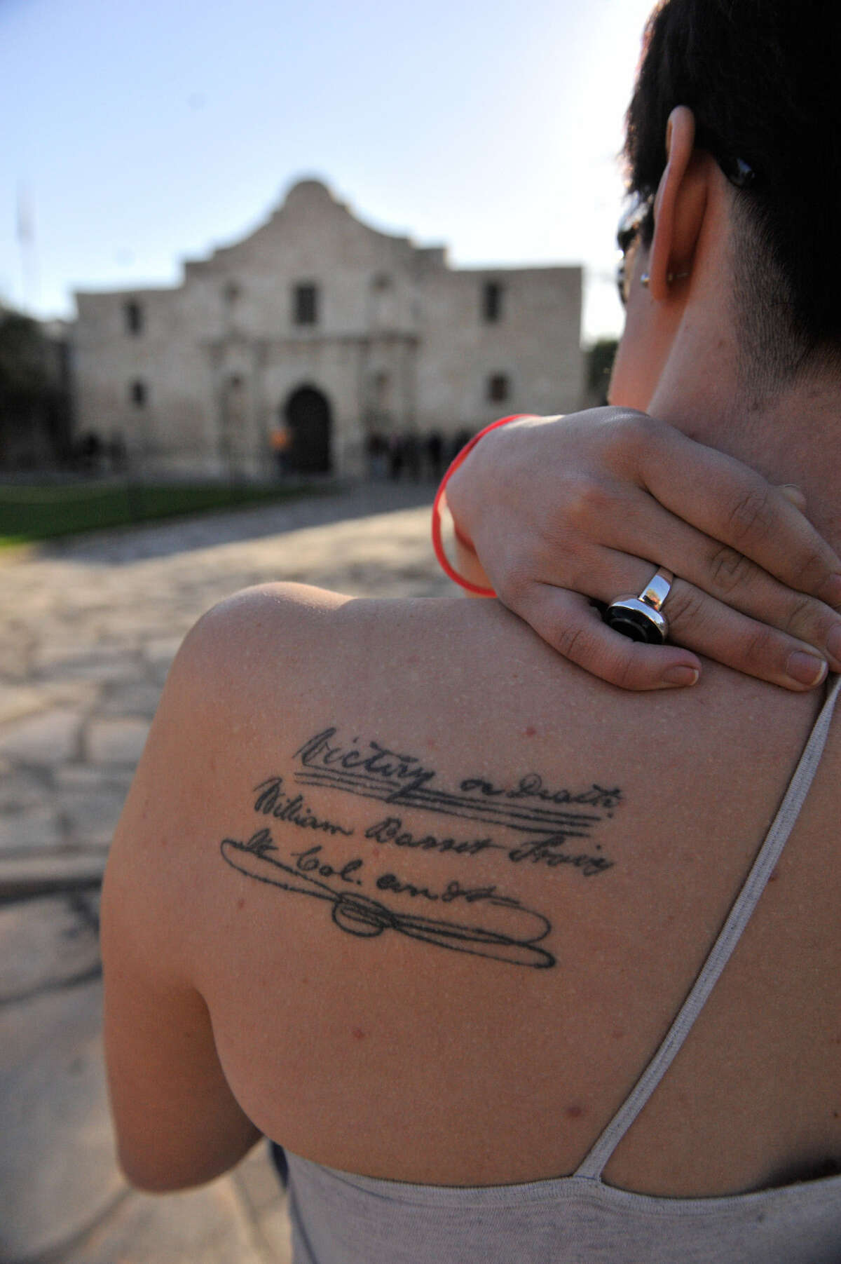Sarah Martin, 22, of Arlington has a replica of the “victory or death” quote tattooed to her back. She was at the Alamo on Friday.